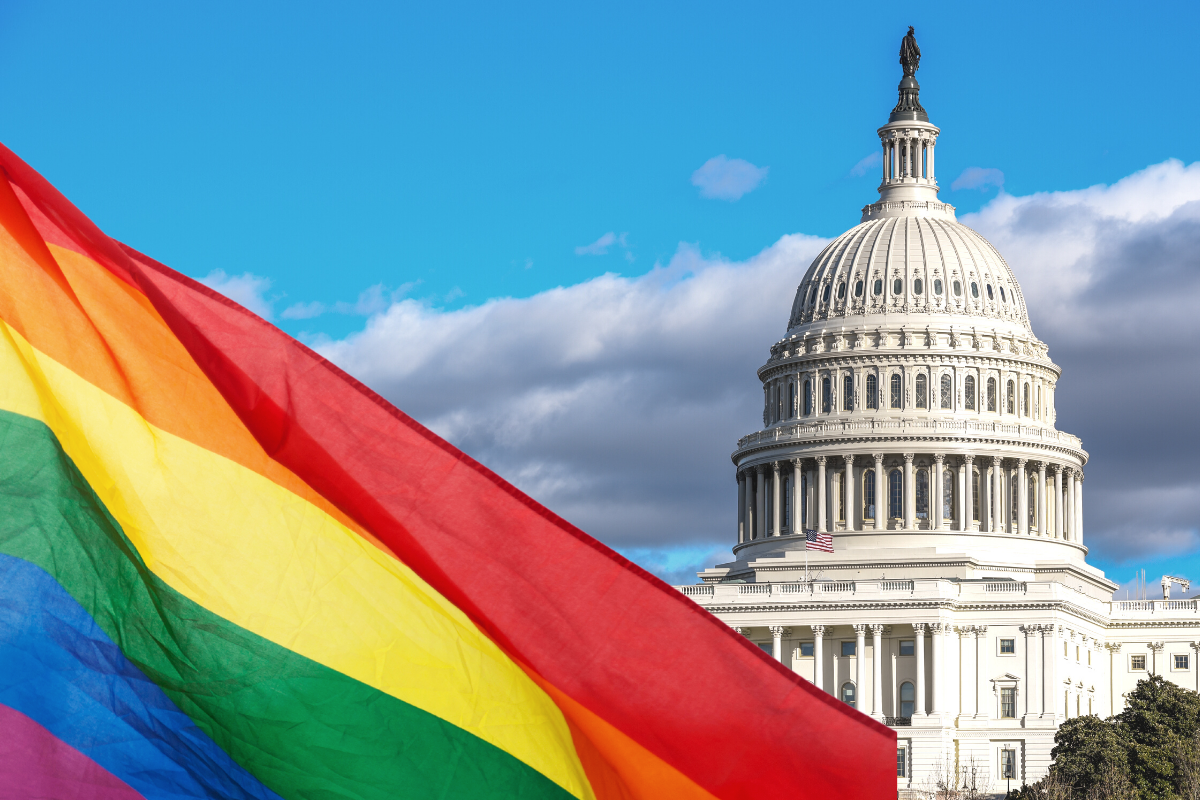 A rainbow flag in front of the United States capitol building.